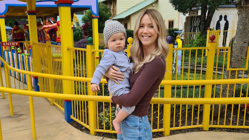 kellie holds lane in front of ride at theme park