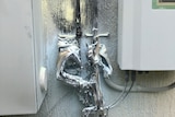 A damaged solar isolator melted after an explosion, with black smoke marking the attached wall