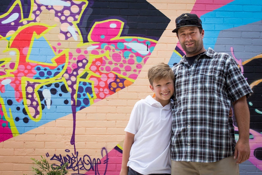 Ryan Beckett with his son Luke, who is already eagerly getting involved in street art with his dad.