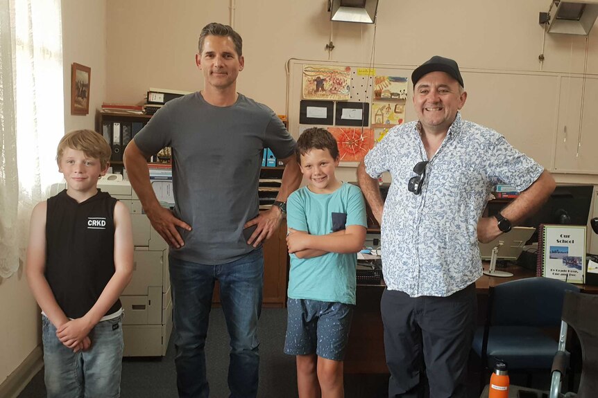 Actor Eric Bana and director Robert Conolly stand beside two local children