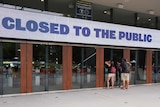 A sign reading "closed to public" is seen outside the MCG.