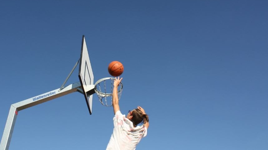 Photo of someone shooting a basketball through a hoop