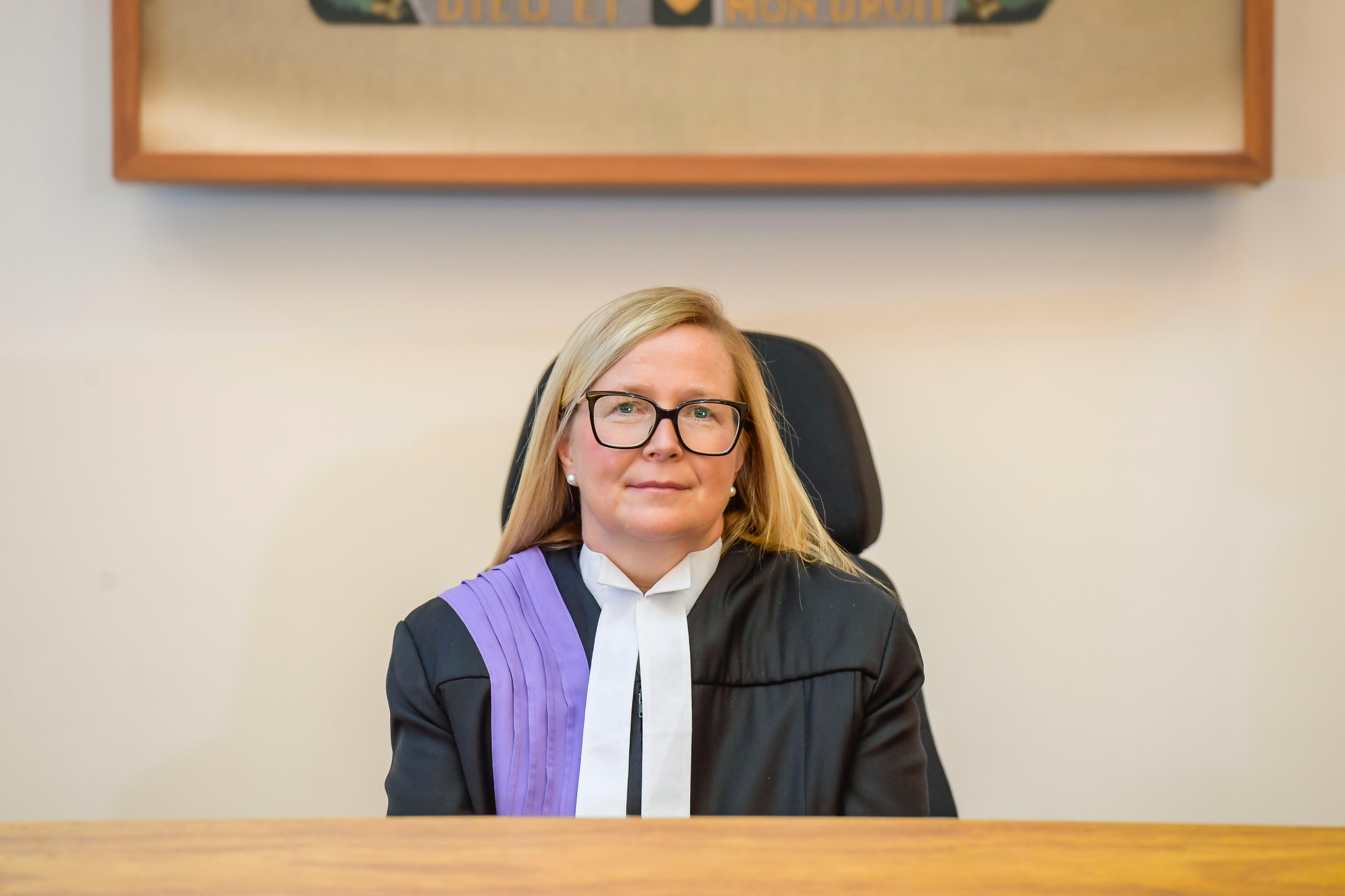Female District Court judge in robes in a court room