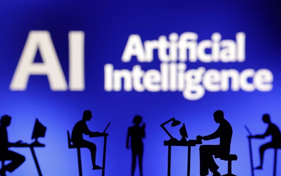 Figurines with computers and smartphones are seen in front of the words "Artificial Intelligence AI" in this illustration.