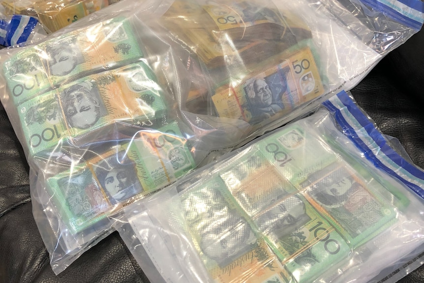 Plastic evidence bags containing wads of $50 and $100 notes