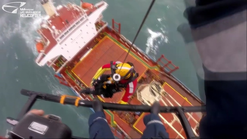 A man is winched down onto a ship