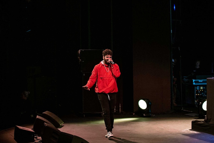 Colour photo of rapper Philly performing on stage at Sydney Opera House.