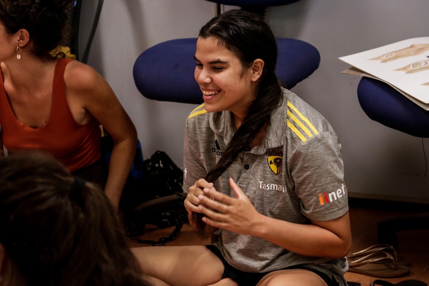 Megan Campbell smiles and holds a long ponytail as she takes part in training.