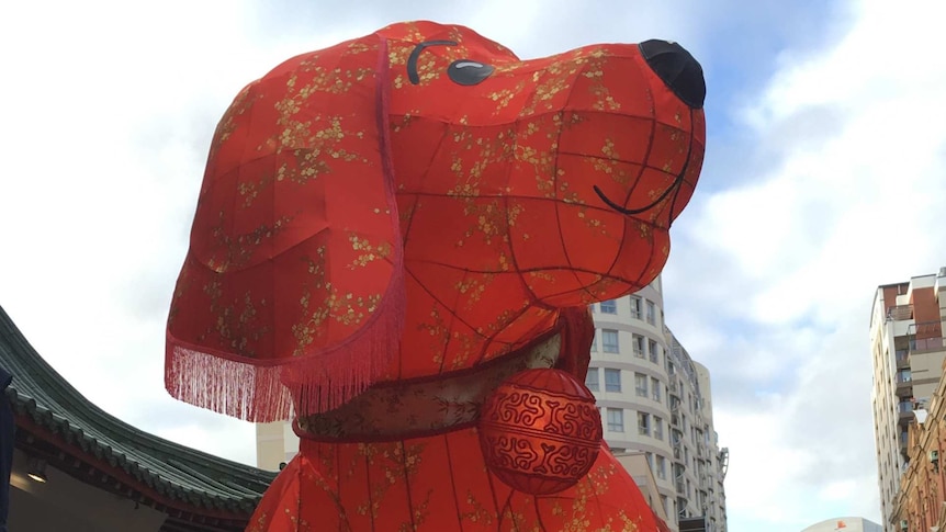 A cartoon red dog lantern sits on a roof.