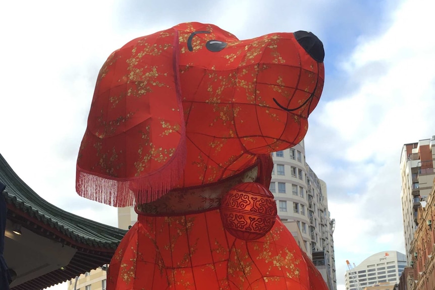 A cartoon red dog lantern sits on a roof.