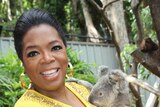 Oprah Winfrey cuddles a koala
