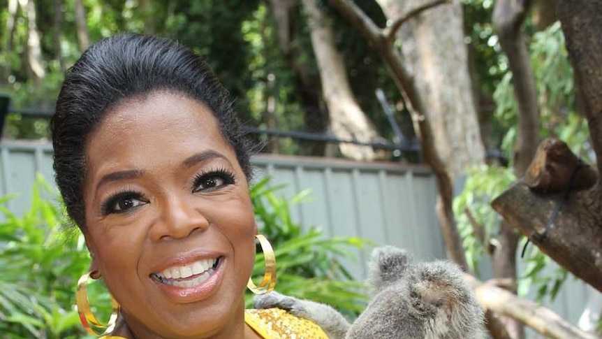 Oprah Winfrey cuddles a koala