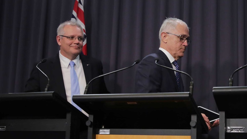 Malcolm Turnbull and Josh Frydenberg walk away from their podiums as Scott Morrison stands at his.