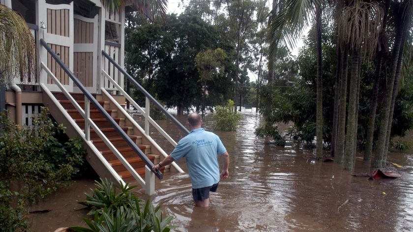 A resident wades through floodwaters to get to his house in the Brisbane suburb of Ashgrove on May 20, 2009, after torrential rain had fallen in the preceding two days.