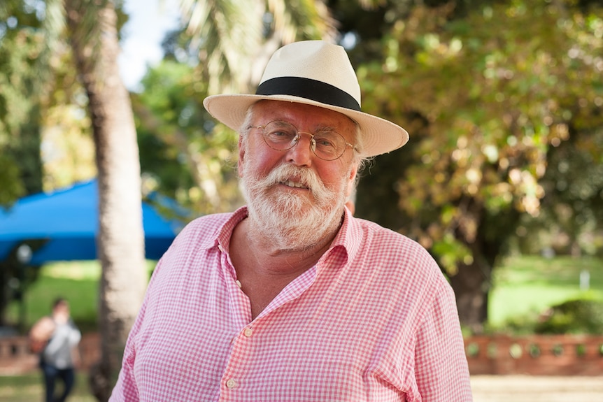 Rodney Twiss wears a pink shirt, straw hat and round glasses at the Adelaide Writers' Festival