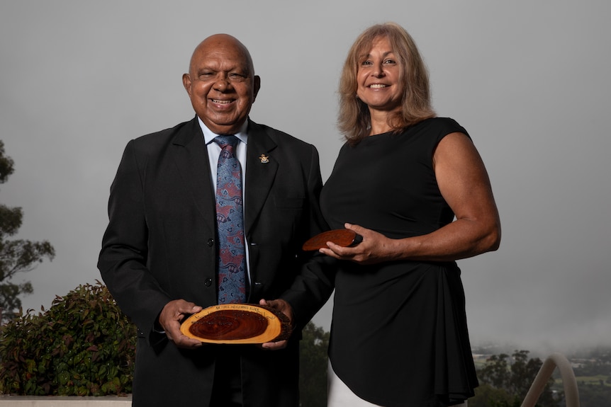 Two Aboriginal people pose for a photo 