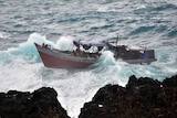 An asylum seeker boat is tossed in heavy seas off Christmas Island