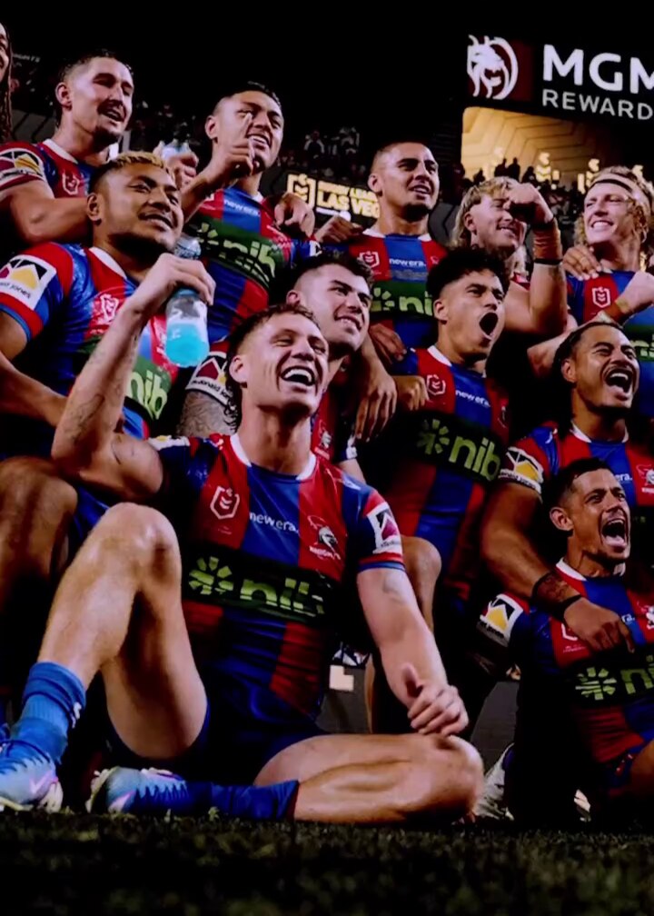 a group of rugby league players cheering and celebrating a win together