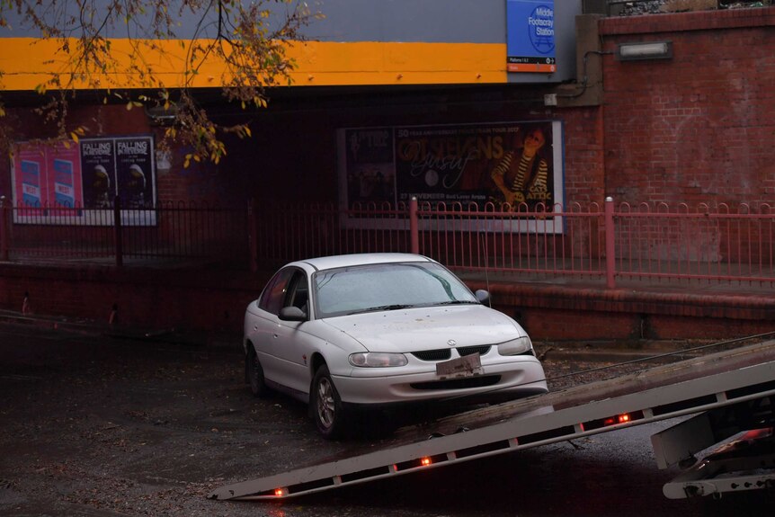 A car stuck in flash flood waters on Victoria Street, Footscray, is towed away.