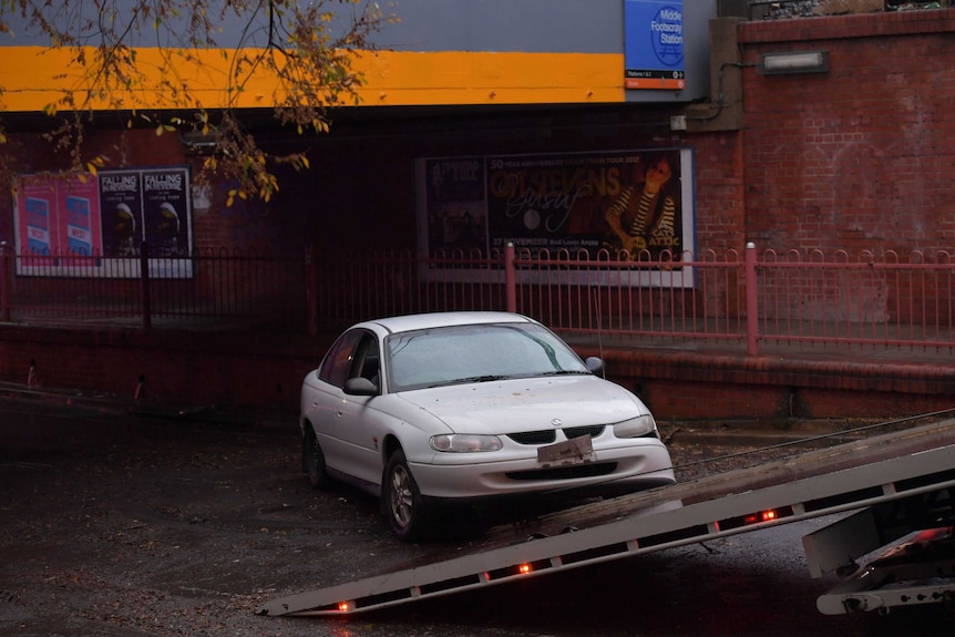 A car stuck in flash flood waters on Victoria Street, Footscray, is towed away.