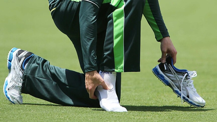 Michael Clarke inspects his ankle during an Australian nets session at Adelaide Oval.