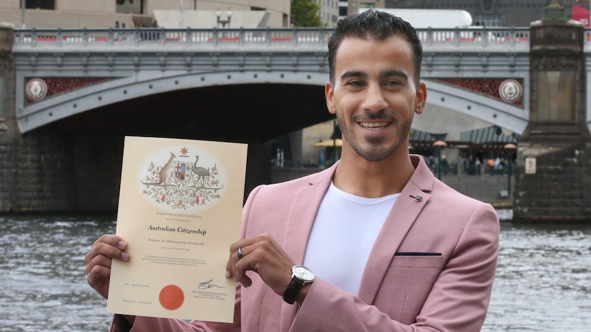 Hakeem al-Araibi smiles and holds his citizenship certificate.