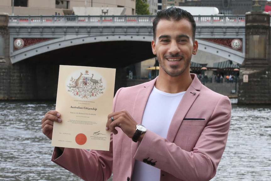 Hakeem al-Araibi smiles and holds his citizenship certificate.