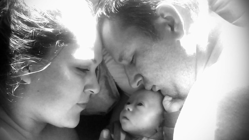 black and white photo of Claire and her husband with Xavier