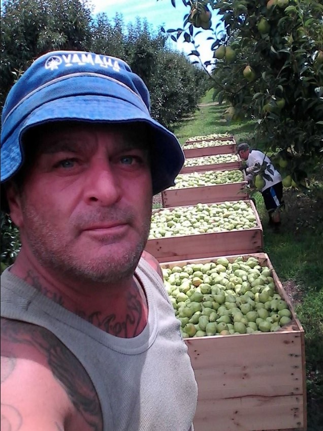 A photo of Umit Bolat next to fruit trees taken from Facebook.