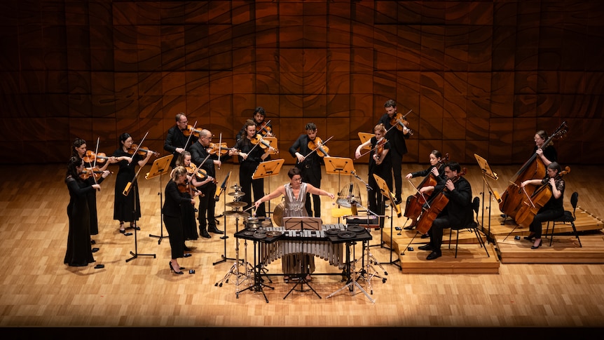 Percussion soloist Claire Edwardes onstage with the Melbourne Chamber Orchestra, dressed in a silver gown.