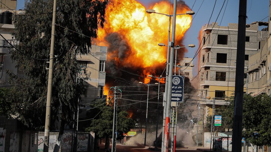 An explosion is seen among buildings and powerlines. 