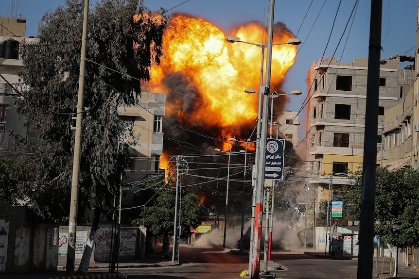 An explosion is seen among buildings and powerlines. 