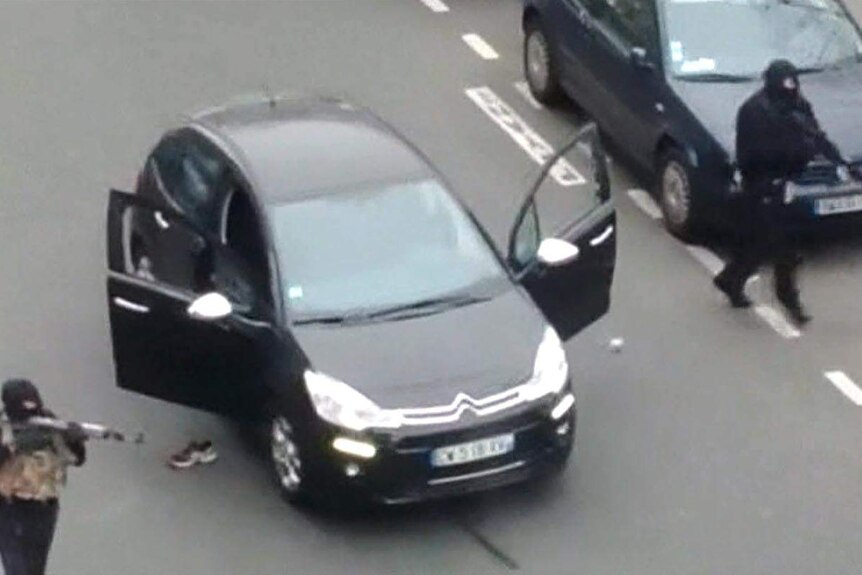 Two gunmen leave their vehicle outside the Charlie Hebdo offices in Paris