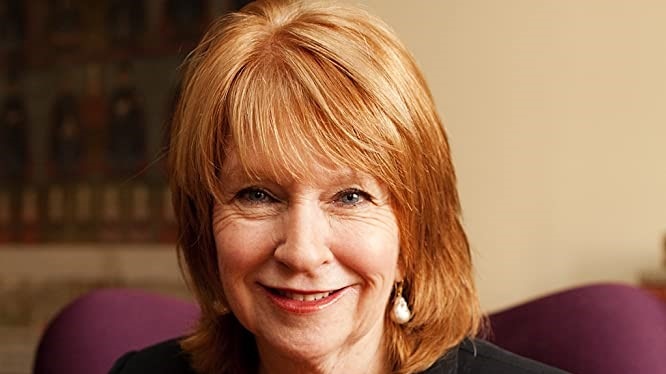 Woman Jan Chapman sitting in chair smiling at camera