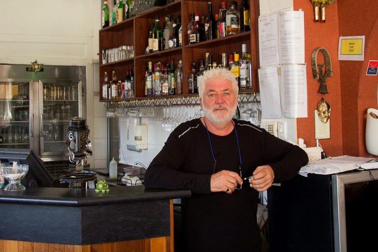 Owner Enzo de Velta stands at the bar inside Romany Restaurant wearing a black jumper.