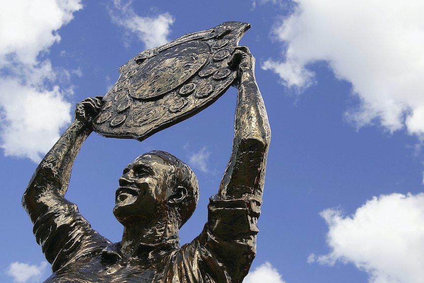 The Wally Lewis statue with a blue sky above.