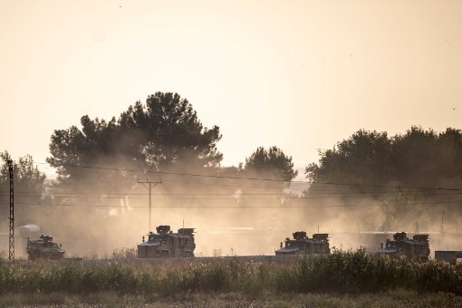 Tanks roll across a dusty road