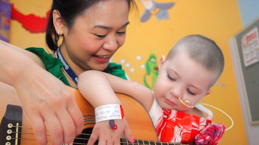 Paediatric music therapist Maggie Leung with a young patient at Lady Cilento Children's Hospital, Brisbane.