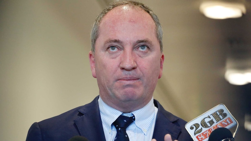 Barnaby Joyce gestures for microphones to get out of his face
