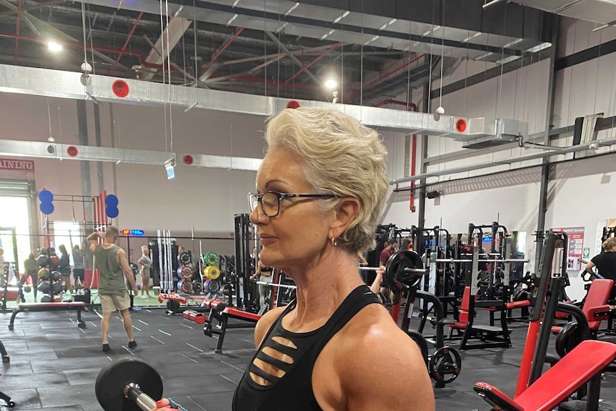 A woman lifts a barbell