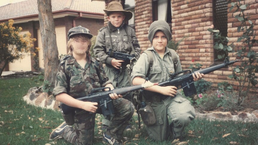 Dan Pronk and his brother Ben as kids dressed in army fatigues and holding toy guns