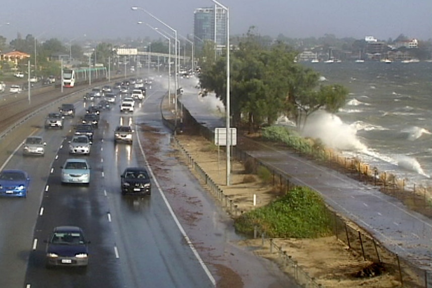 Water from the river sprays over cars on the freeway.