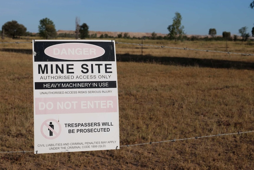 a sign on a barbed wire fence reads "mine site, authorised access only"