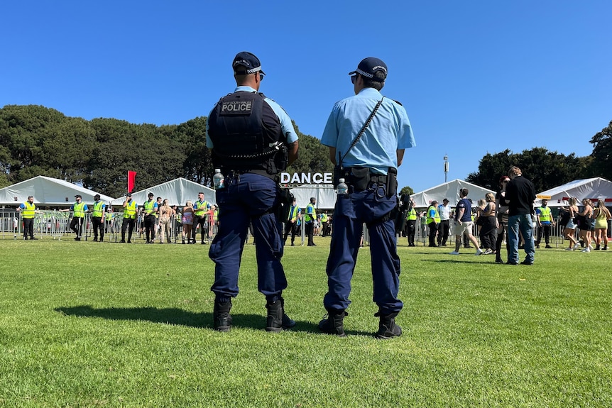 Two police officers standing outside a festival 