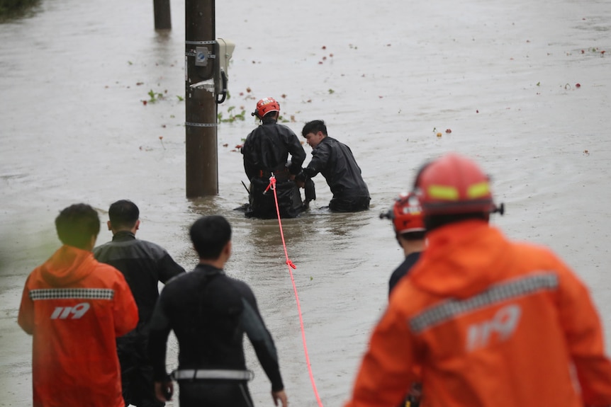 South Korean firefighters rescue someone trapped in floodwaters