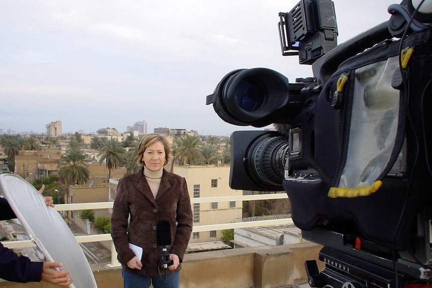 Hutcheon standing on a roof talking to camera.