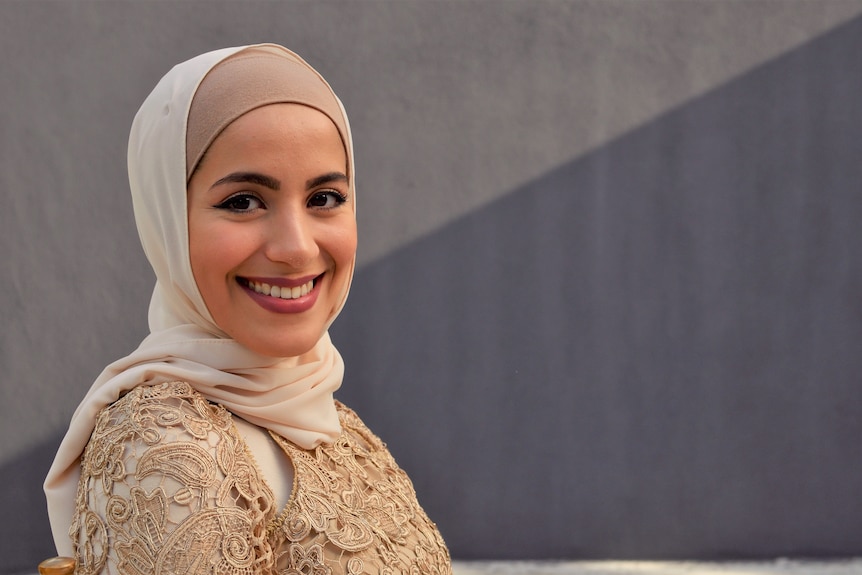 A woman wearing head covering smiling to camera