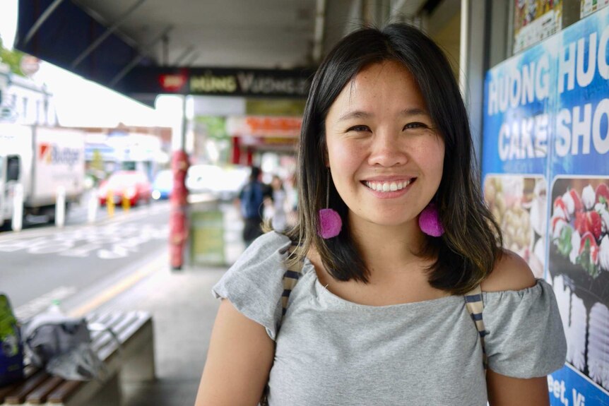 Comedian Diana Nguyen on a street in Melbourne's Abbotsford with Vietnamese food shops in the background.