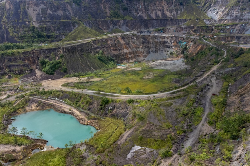 A birds eye view of a mine with a pit and a pool of water.