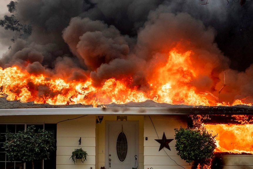 Roof on fire of a home in Paradise where thousands of structures were lost.